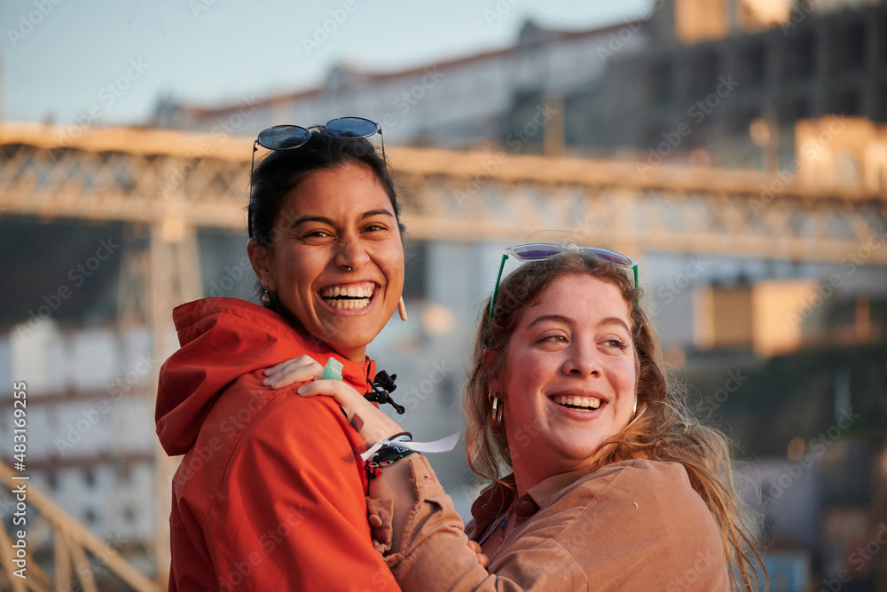 A shallow focus of two reunited friends against the Dom Luis I bridge in Oporto, Portugal A shallow focus of two reunited friends against the Dom Luis I bridge in Oporto, Portugal