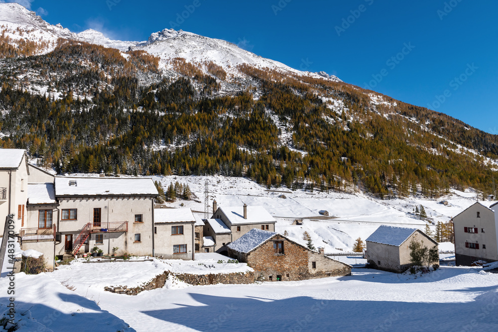 Snow covered Swiss village high in the mountains on a sunny autumn day