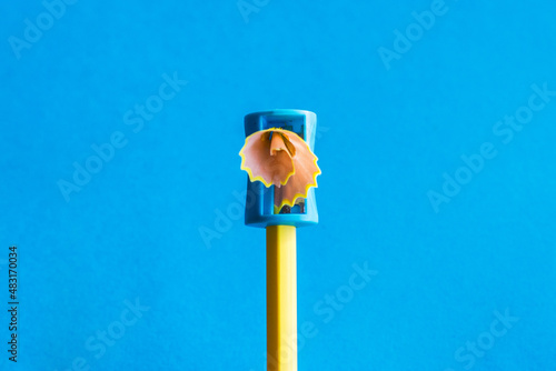 Creativity.
Yellow Pencil That Is Sharpened With A Manual Pencil Sharpener. Blue Background photo