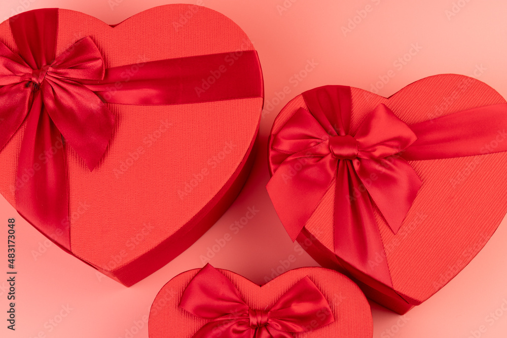 Red box in shape of heart. Gift box for Valentine's Day. Isolated on pink background.