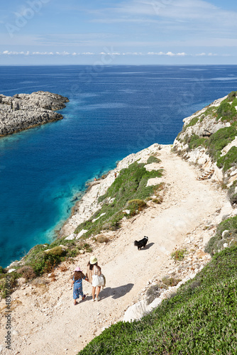 Mother, daughter and dog walking down to the sea in Zakynthos
