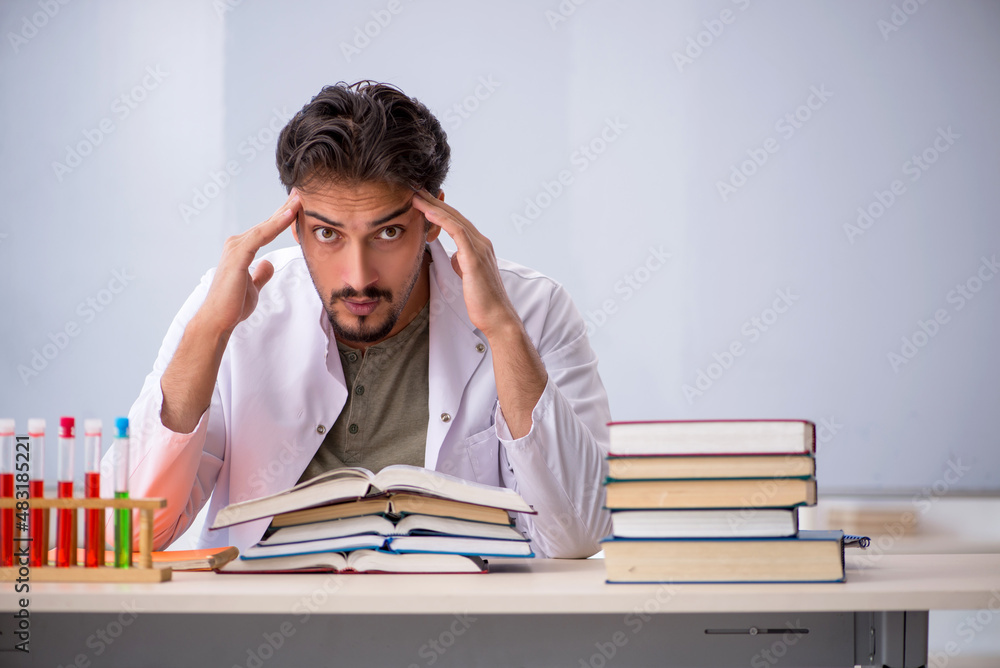 Young male chemist teacher in front of whiteboard Young male chemist teacher in front of whiteboard