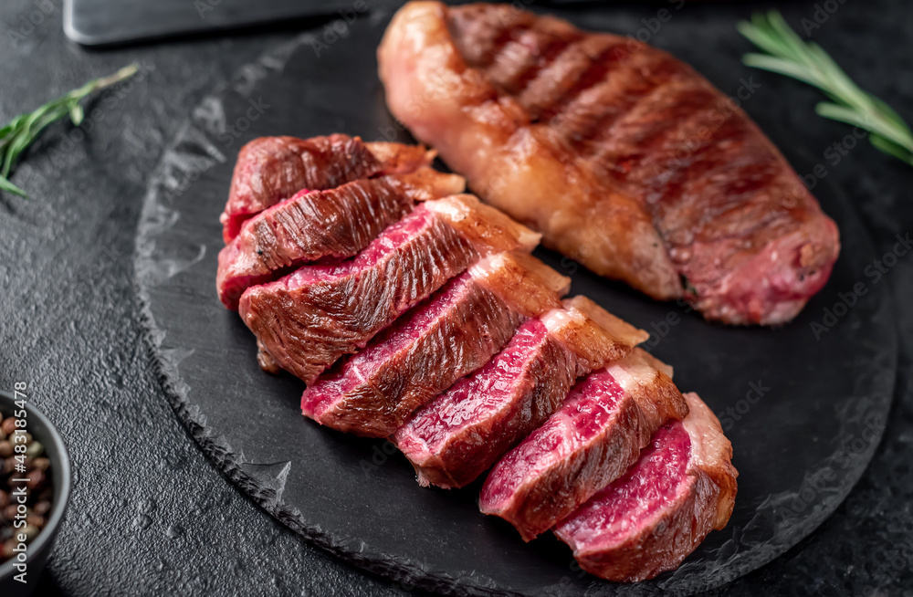 Two grilled picanha steaks with spices on a stone background Two grilled picanha steaks with spices on a stone background