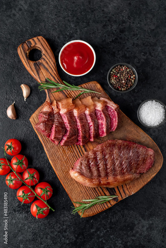 Two grilled picanha steaks with spices on a stone background
