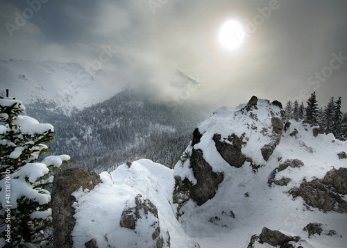 View from Mt Goose Neck  G  sia Szyja  towards the Wo  oszyn Range  with sun beaming through the clouds in winter  Tatra Mountains  Poland