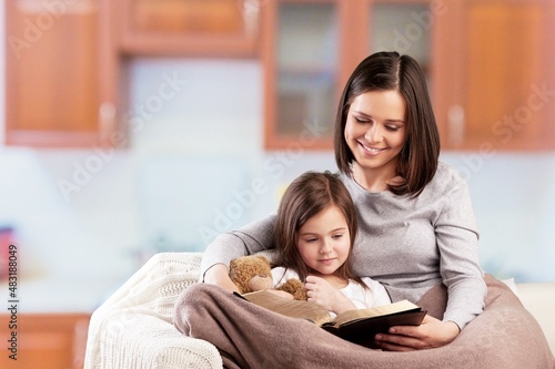 Mom woman with baby girl helper read cookbook