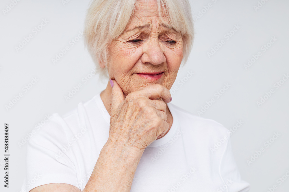 Photo of retired old lady holding his head discontent problem light background Photo of retired old lady holding his head discontent problem light background