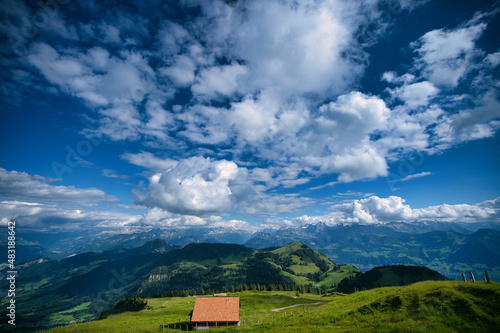 Blue sky with clouds and mountains in sunshine