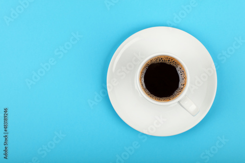 Full white espresso coffee cup over blue