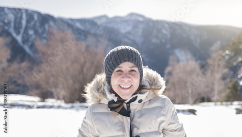 Happy hispanic girl smiling on camera with snowy mountain on background - Winter concept