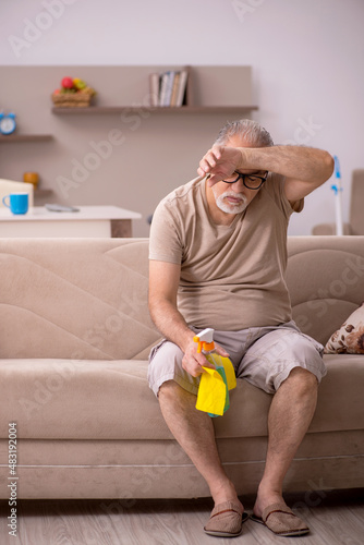 Old man doing housework at home