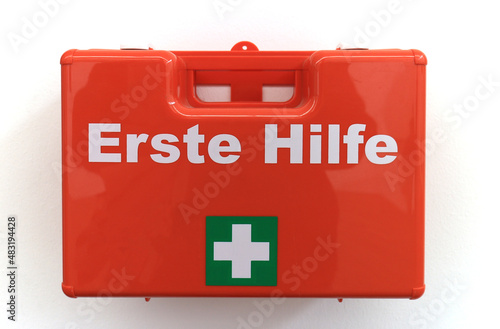 First aid box mounted on a white wall with the German text "Erste Hilfe" which translates into "First aid" in English language