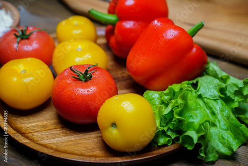 lettuce, yellow and red tomatoes and bell pepper with water drops. cucumbers.