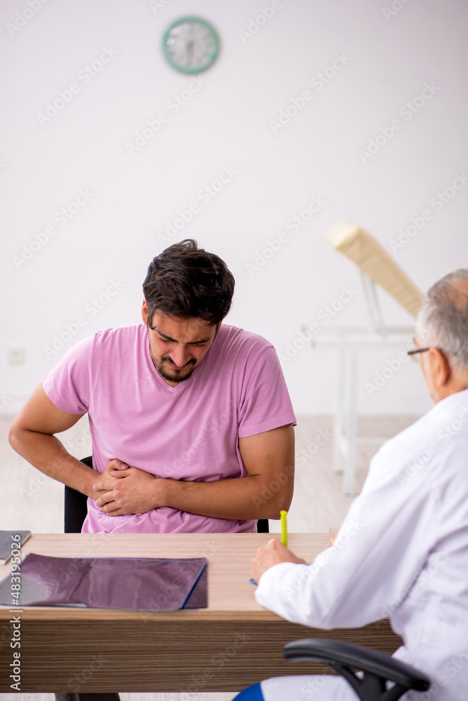 Obraz premium Young male patient visiting old male doctor