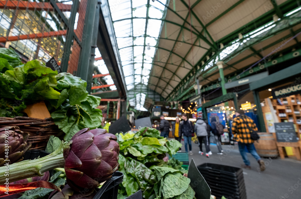 Market stalls at Borough Market, partially covered urban market in Southwark, east London, with a wide range of food and drink stalls. Fresh artichokes in foreground.