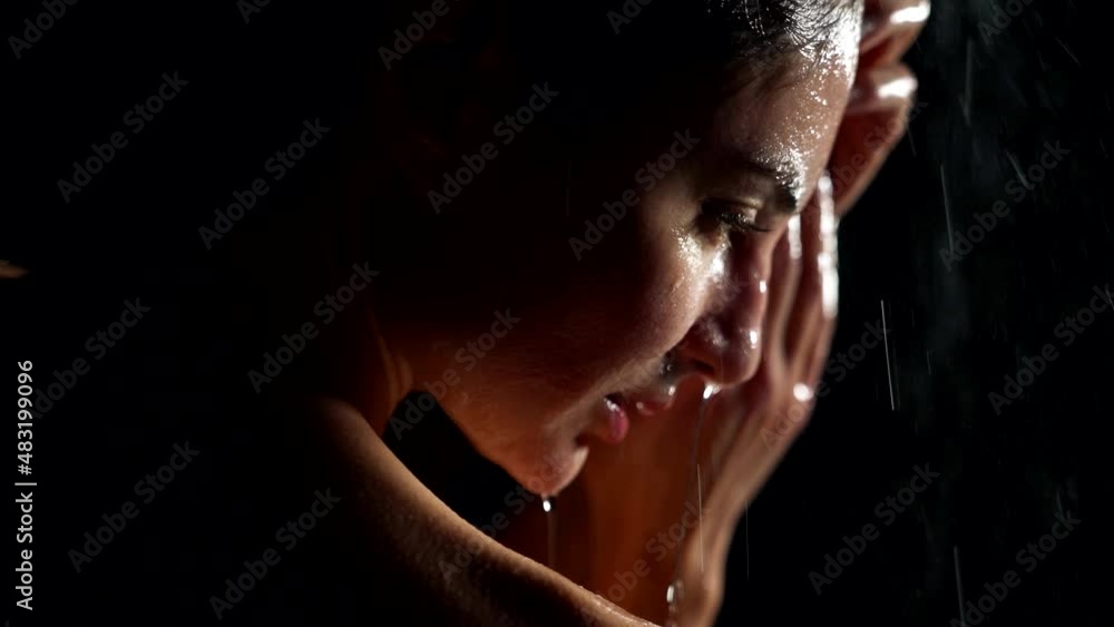 stunning wet woman in darkness, taking shower or posing in rain in night, closeup stunning wet woman in darkness, taking shower or posing in rain in night, closeup
