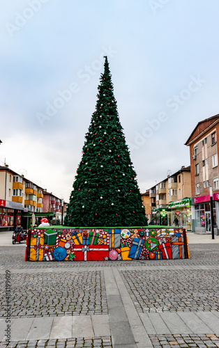Hunedoara, Romania-January 2, 2022: New Year's photo from downtown Hunedoara showing the decorated Christmas tree and people walking relaxed taking a breath of fresh air