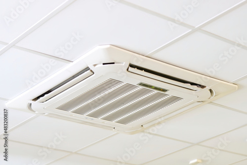 cassette type air conditioner mounted on ceiling wall. Air duct on ceiling in farmacy store. Air flow and ventilation system. close up