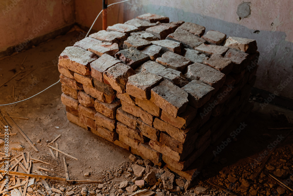 Old, used, dirty red bricks stacked together. Home repair.