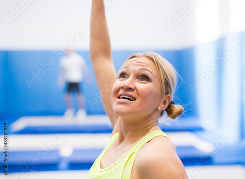 Close up expressive face of female gymnast during training on professional trampoline .. © JackF