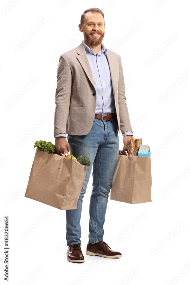 Full length portrait of a smiling young man carrying grocery bags Full length portrait of a smiling young man carrying grocery bags