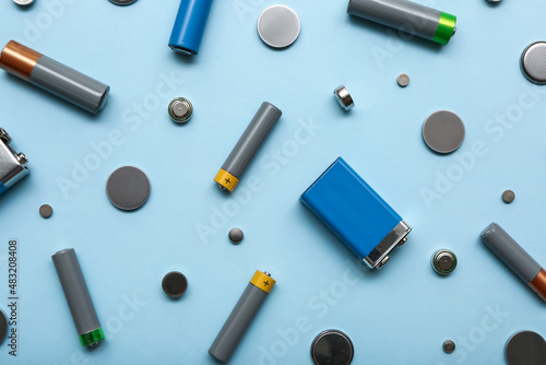 Different batteries on blue background photo