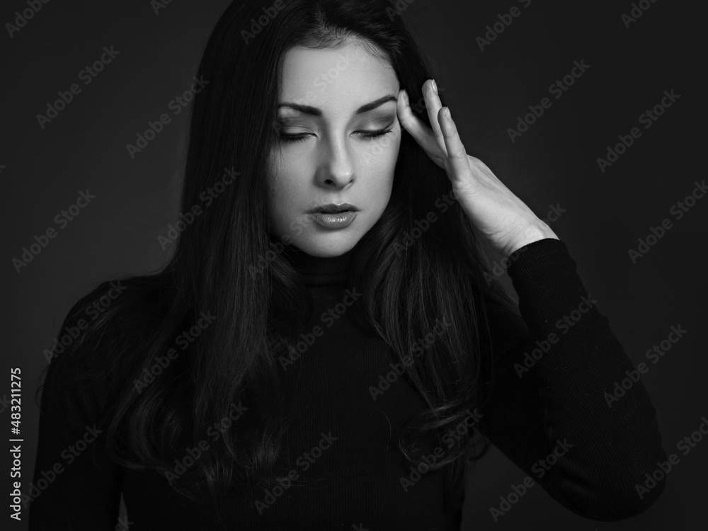 Business concentrate thinking woman find the answer in clever mind with closed eyes with fingers near the face in black sweater on dark shadow red background. Closeup front Business concentrate thinking woman find the answer in clever mind with closed eyes with fingers near the face in black sweater on dark shadow red background. Closeup front