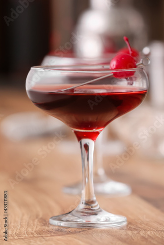 Glass of tasty Manhattan cocktail on wooden table, closeup
