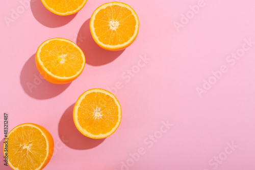 Fresh cut oranges on pink background