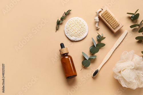 Composition with bath supplies, bottle of essential oil and eucalyptus branches on color background