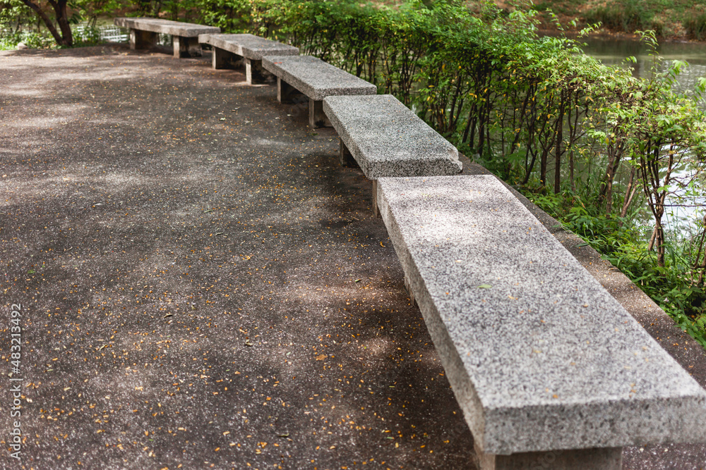 Stone benches stands in circle in urban recreation park Lumpini. Street seats made of concrete. Places for local residents and tourists to relax. Bangkok, Thailand.