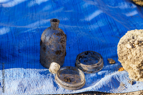 Retro glass medical containers on blue burlap. Archaeological excavations of criminologists for examination. Background photo