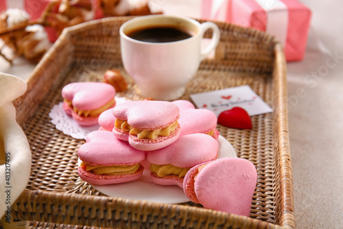 Tray with tasty heart-shaped macaroons on table