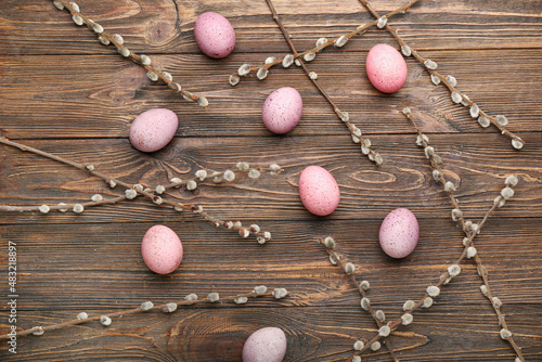 Composition with beautiful Easter eggs and pussy willow branches on wooden background