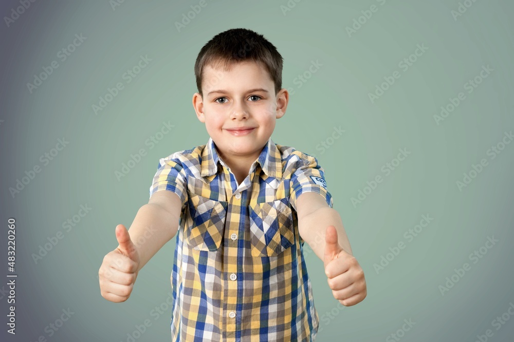 Happy child shows thumbs up gesture with both hands Happy child shows thumbs up gesture with both hands