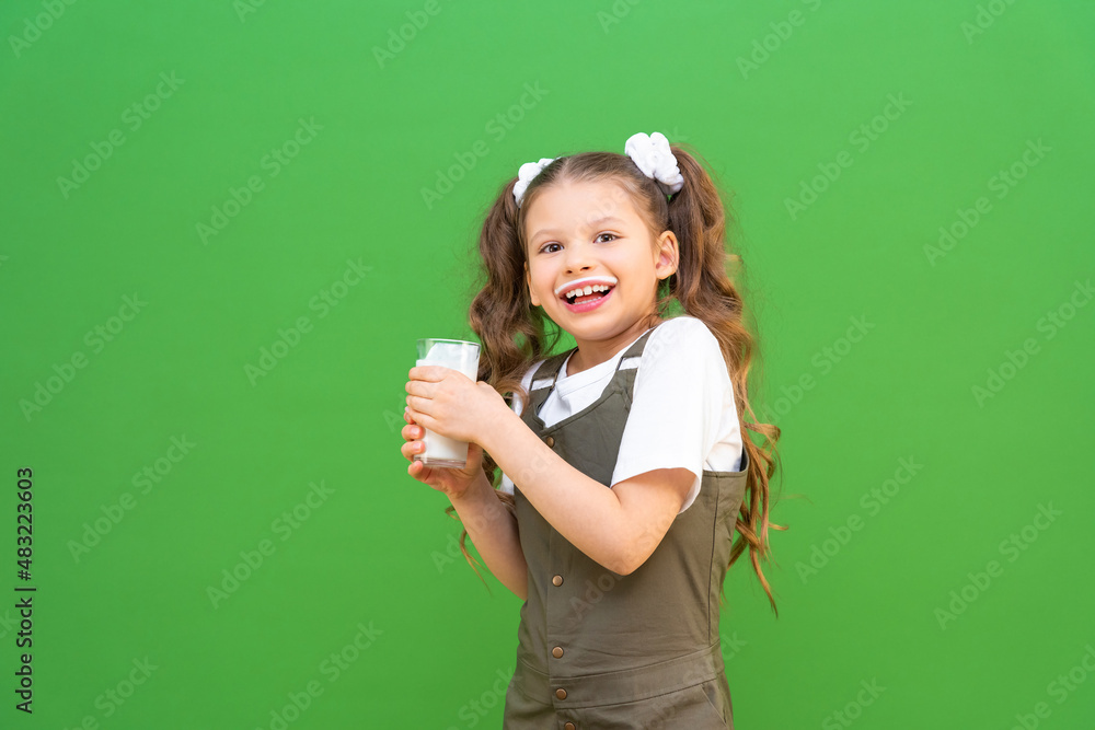 A child with a glass of kefir is very surprised. Proper nutrition for children. Calcium for bone growth. A child with a glass of kefir is very surprised. Proper nutrition for children. Calcium for bone growth.