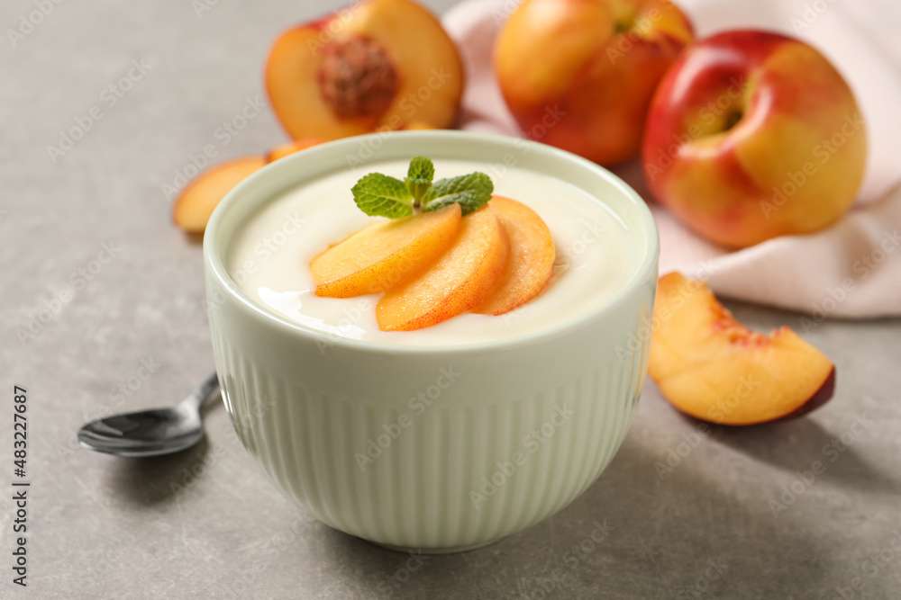 Delicious yogurt with fresh peach and mint on grey table, closeup Delicious yogurt with fresh peach and mint on grey table, closeup