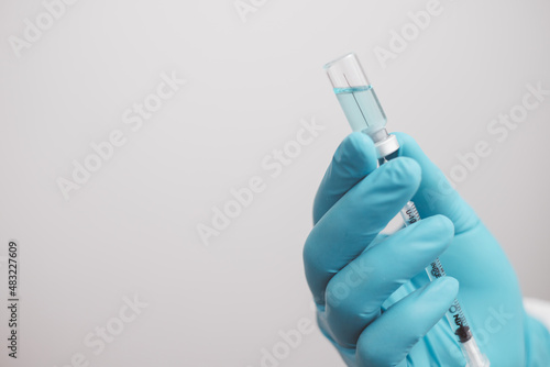 doctor or scientist in the COVID-19 medical vaccine research and development laboratory holds a syringe with a liquid vaccine to study and analyze antibody samples for the patient. 