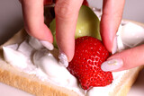 フルーツサンド作り　食パンにイチゴを乗せる女性の手