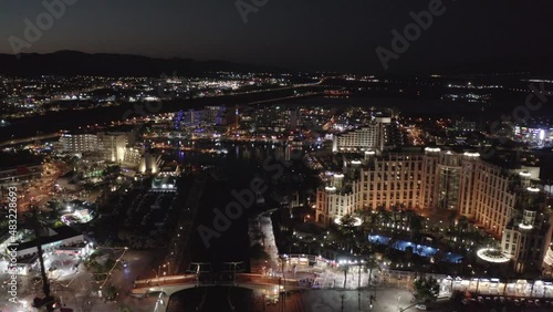 Wallpaper Mural Multiple flashing lights during nightlife in Eilat witht the beautiful lit Queen of Sheba hotel and silhouettes of mountains in the background. Night drone dolly shot Torontodigital.ca