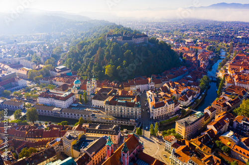 Panoramic aerial view of Ljubljana downtown with ancient castle complex on hilltop in sunny autumn morning, Slovenia photo