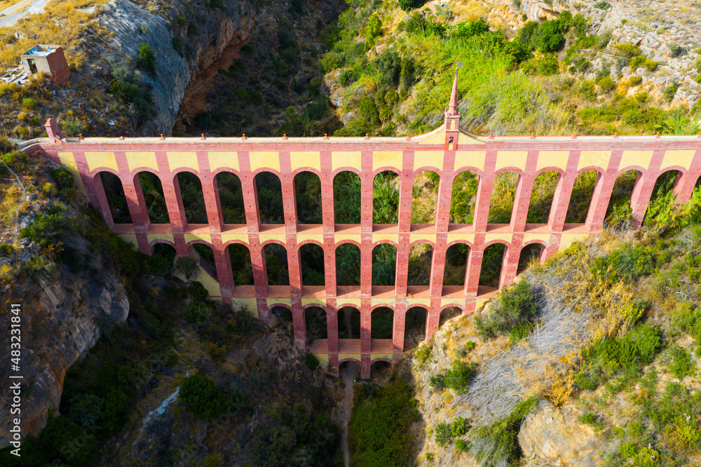 View of restored Eagle Aqueduct (Puente del Aguila) with four levels of arches passing water for local irrigation in Spanish city of Nerja..
