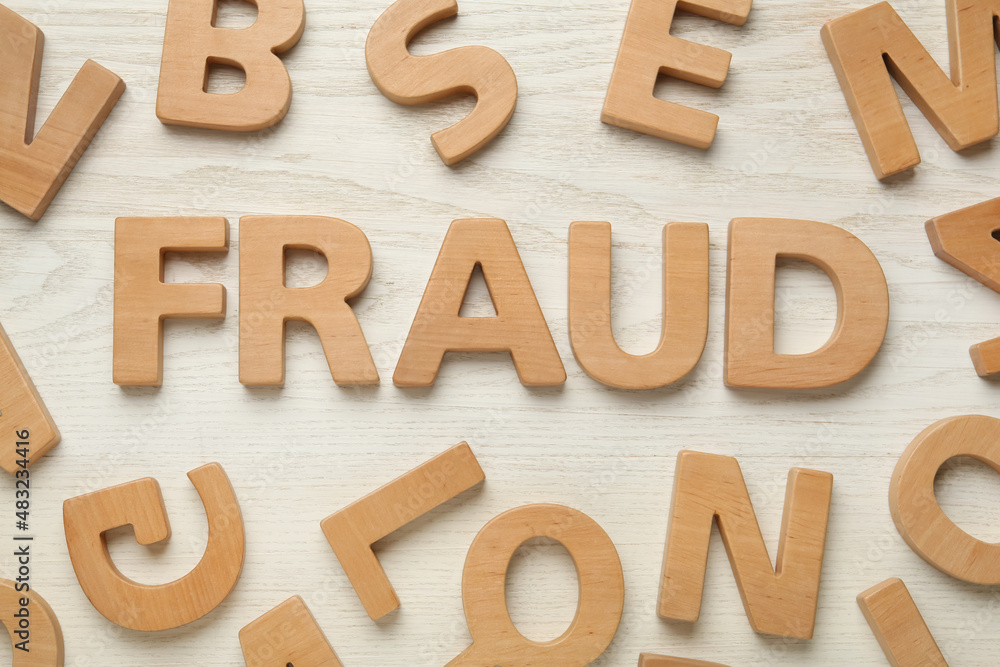 Word Fraud surrounded by wooden letters on white background, flat lay Word Fraud surrounded by wooden letters on white background, flat lay