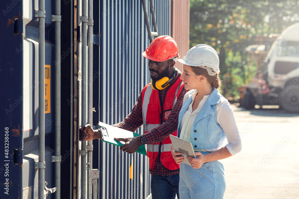 Businesswoman and engineer talking and checking loading Containers box from Cargo freight ship for import export. shipping in docks. Businesswoman and engineer talking and checking loading Containers box from Cargo freight ship for import export. shipping in docks.