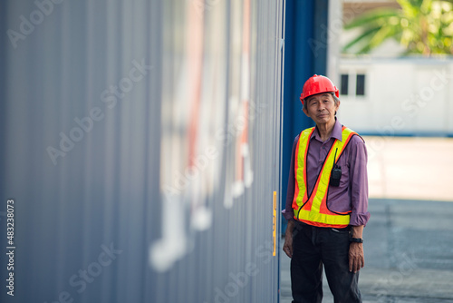 Foreman standing to rest at container in the container yard. Logistics concept .