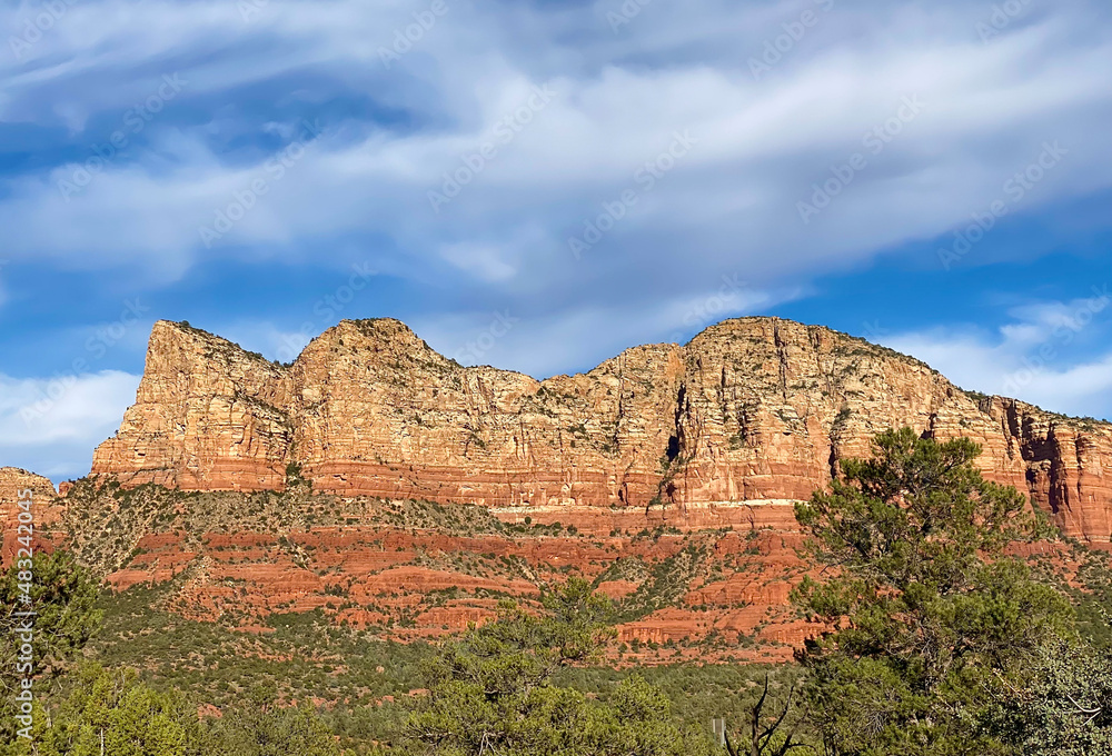 The red rock formations reaching for the sky as the sun warms the stone and highlights the autumn leaves is a typical scenic landscape in the spiritual, beautiful Sedona, Arizona in western USA The red rock formations reaching for the sky as the sun warms the stone and highlights the autumn leaves is a typical scenic landscape in the spiritual, beautiful Sedona, Arizona in western USA