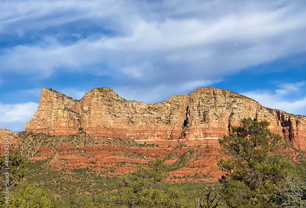 The red rock formations reaching for the sky as the sun warms the stone and highlights the autumn leaves is a typical scenic landscape in the spiritual, beautiful Sedona, Arizona in western USA