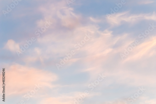 Background of blue sky with white pink clouds in sunset