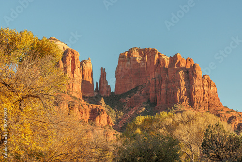 The red rock formations reaching for the sky as the sun warms the stone and highlights the autumn leaves is a typical scenic landscape in the spiritual, beautiful Sedona, Arizona in western USA