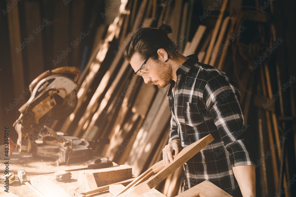 The carpenters man high experienced wood worker making furniture. master of woodcraft male looking at workpiece closeup with fine detail.